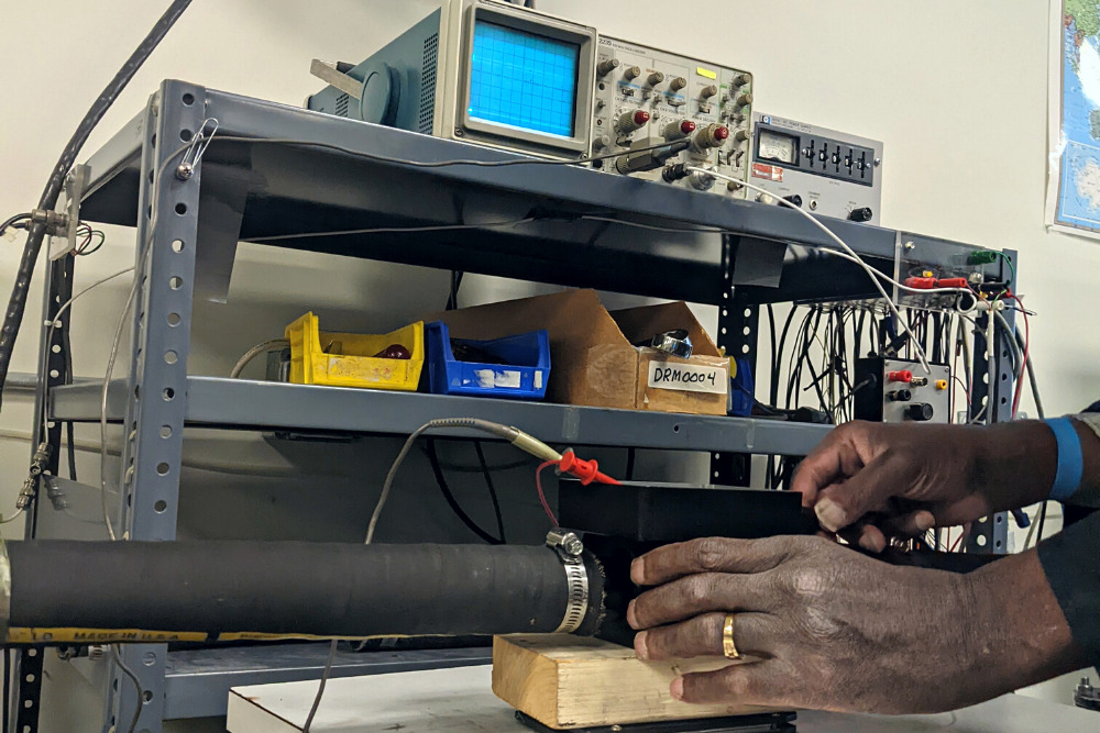 J-TEC’s cleaning and calibration lab, with a team member hooking up a flow meter to the test stand for testing.